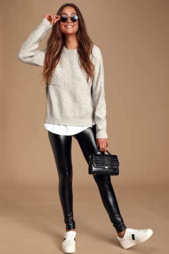 Cool outfit for Christmas with black leather leggings, white sneakers, white button-down shirt, oversized gray sweater, and black mini bag