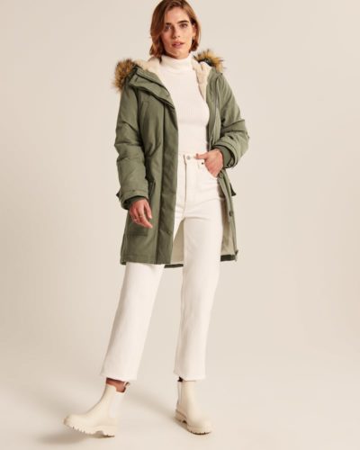 Parka outfit with cream wide leg jeans, cream turtleneck, cream chelsea boots, and army green puffer jacket