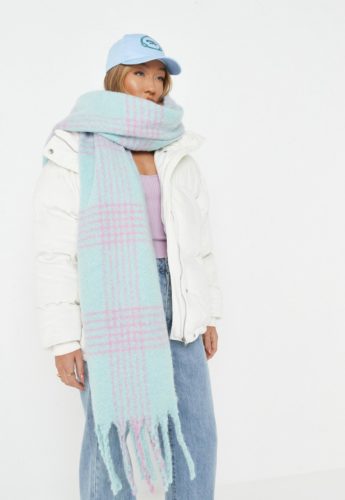 Oversized scarf outfit with blue wide leg jeans, lavender cropped sweater, oversized white puffer coat, blue and lavender oversized scarf, and light blue baseball cap