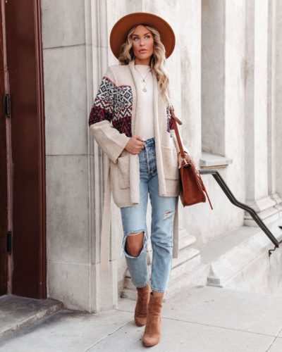 Vici Boho Cardigan paired with ripped mom jeans, white high neck bodysuit, layered gold necklace, wide brim camel hat, camel bag, brown suede ankle booties