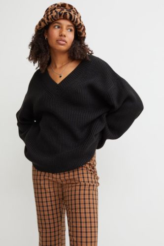 Oversized sweater outfit with brown checkered pants, black oversized sweater, fuzzy leopard print hat