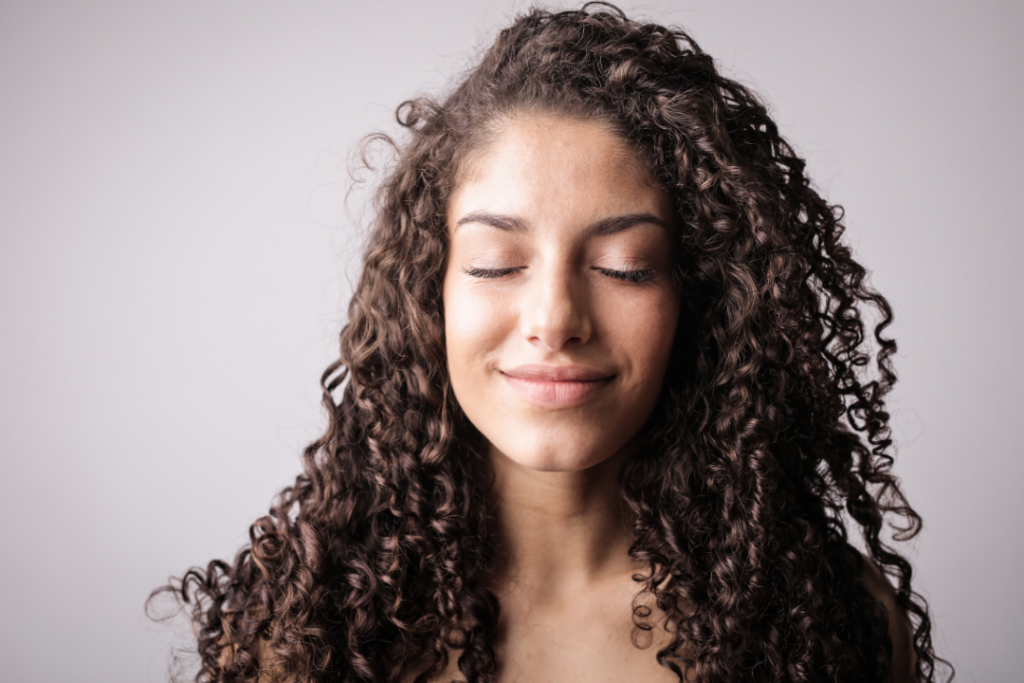 Photo of a woman rocking her natural curls and frizzy hair