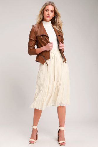 Neutral Christmas outfit from Lulus with cream colored skirt, cream turtleneck, strappy cream heels, and a brown moto jacket