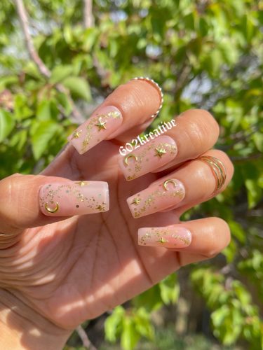 Nude nails with gold moon and stars details