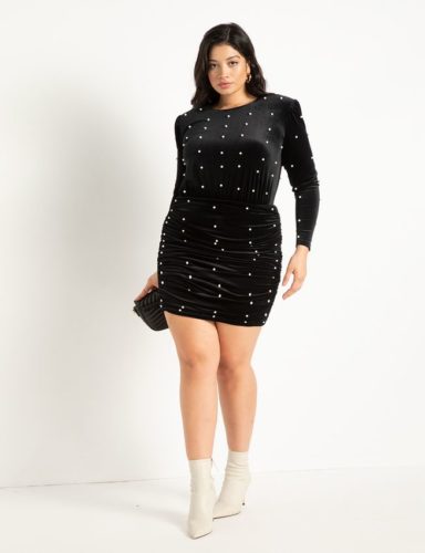 Black velvet mini dress with pearl embellishments paired with white ankle boots and a black clutch