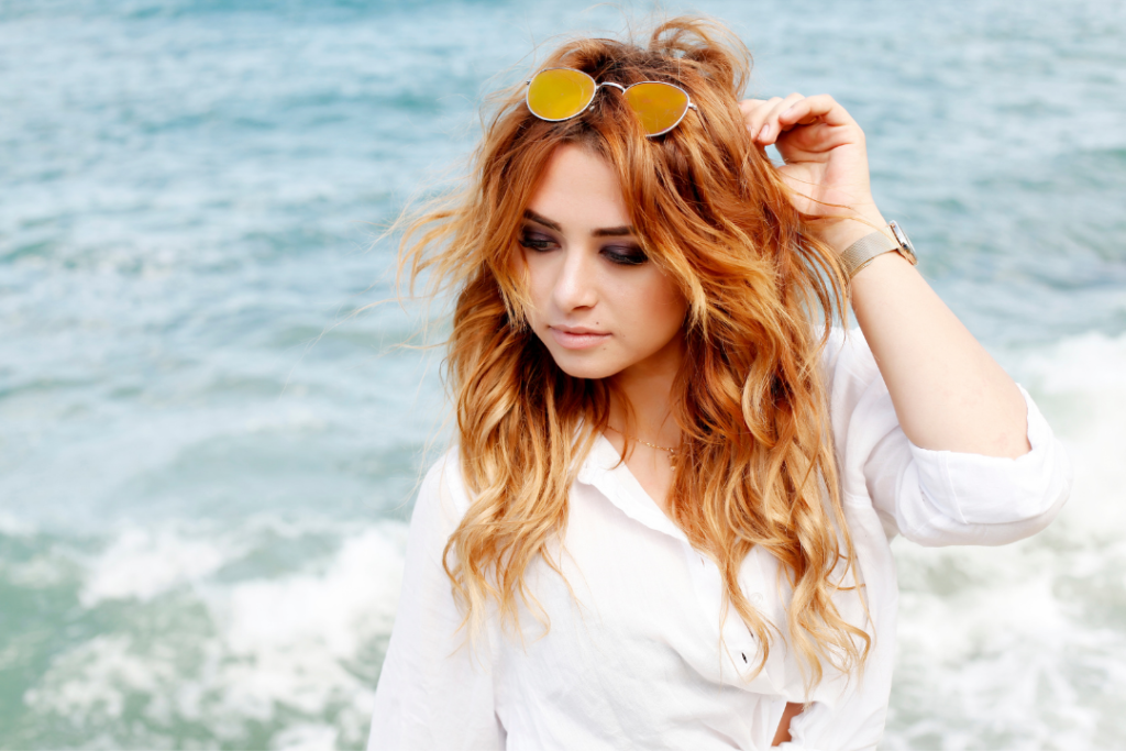 Woman rocking frizzy and wavy hair and side swept bangs