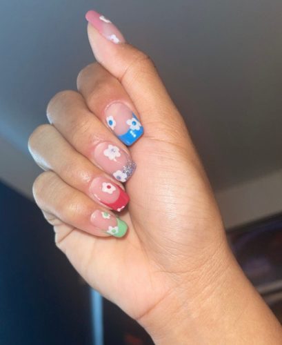 Colorful french tip nails with white flowers on top