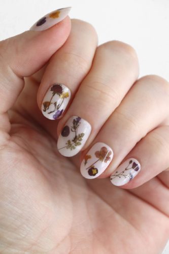 Dried flower nail stickers from Etsy seen on white nails