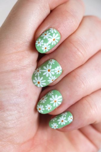 Green nails with white daisies on them