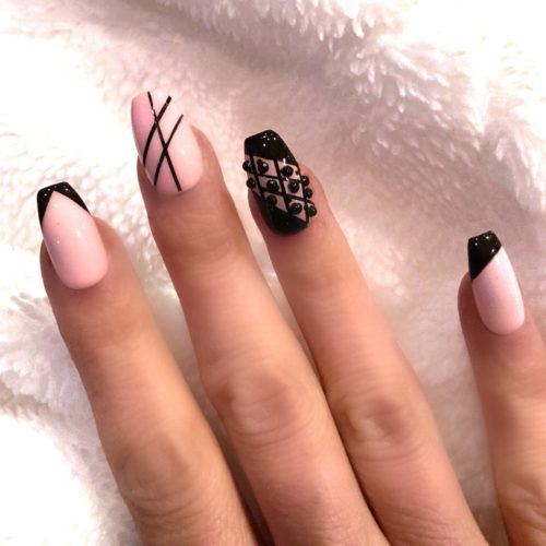 Pink nails with black lines and studded detailing