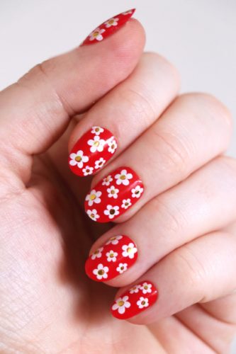 Red nails with gold and white flower nail art