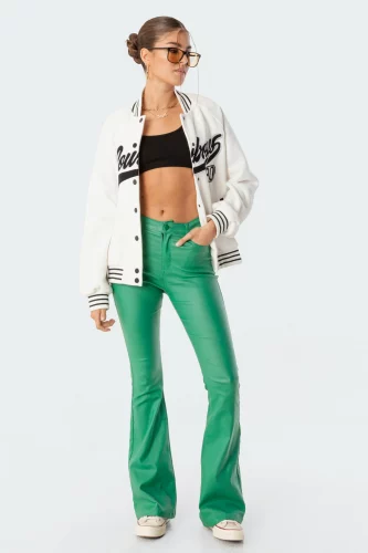 Edikted Green Faux Leather Jeans paired with a black crop top and white varsity jacket