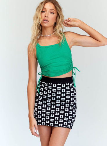 Princess Polly Green Top paired with black high waisted printed mini skirt