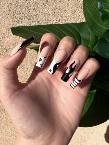 Black and white yin yang nails with flames, stripes, and star accent nails