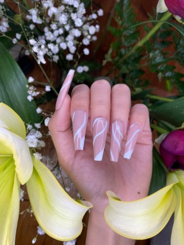 Nude long coffin shaped nails with white swirls design