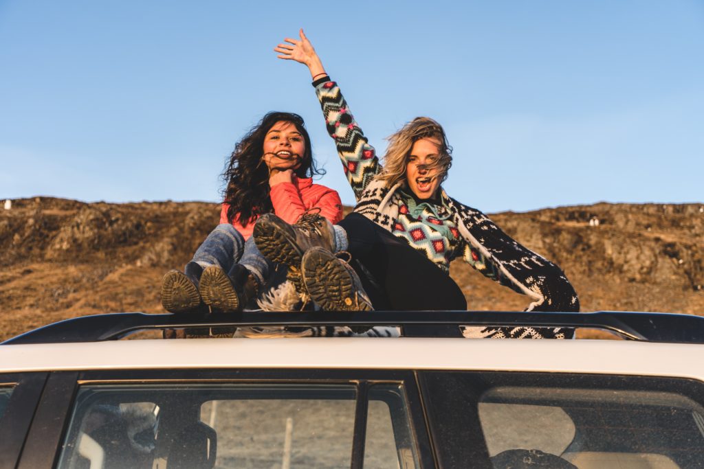 Road trip photo of two girls riding in a car from unsplash