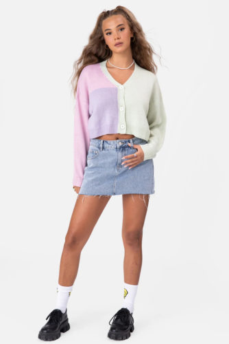Adika Cardigan in green, purple, and pink, paired with a cutoff denim skirt, smiley face socks, and black loafers