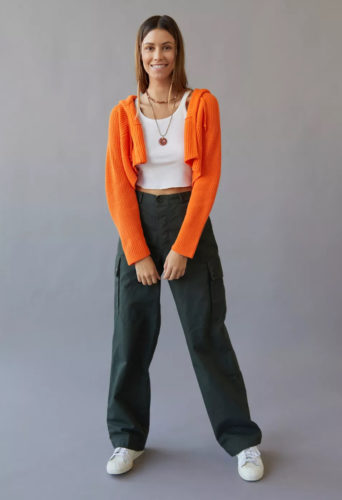 UO Crop Cardigan in orange paired with wide leg cargo pants, white sneakers, and a white crop top for a cute outfit for teens