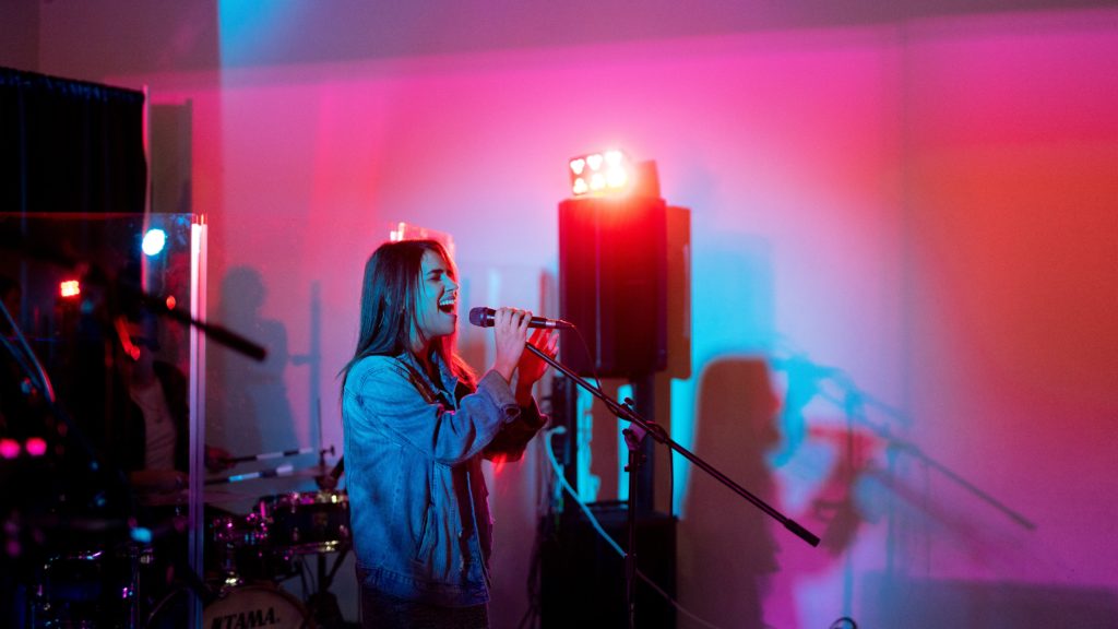 Photo of a woman singing karaoke from unsplash - 20th birthday ideas