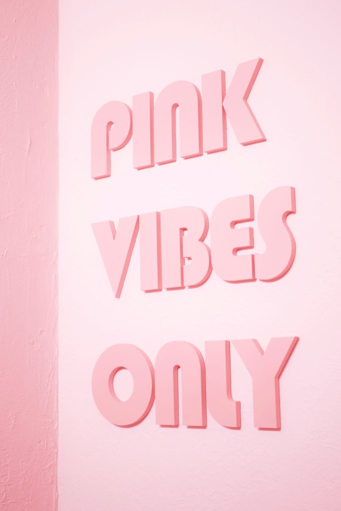 Photo of a pink wall with the words 
