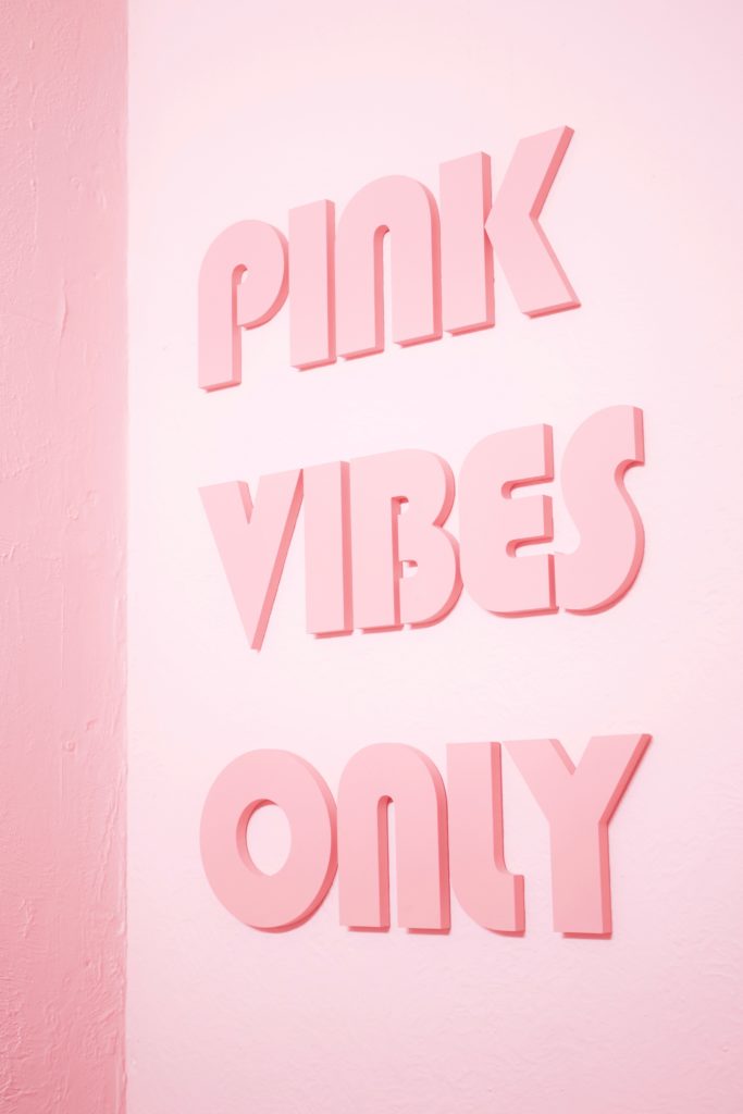 Photo of a pink wall with the words
