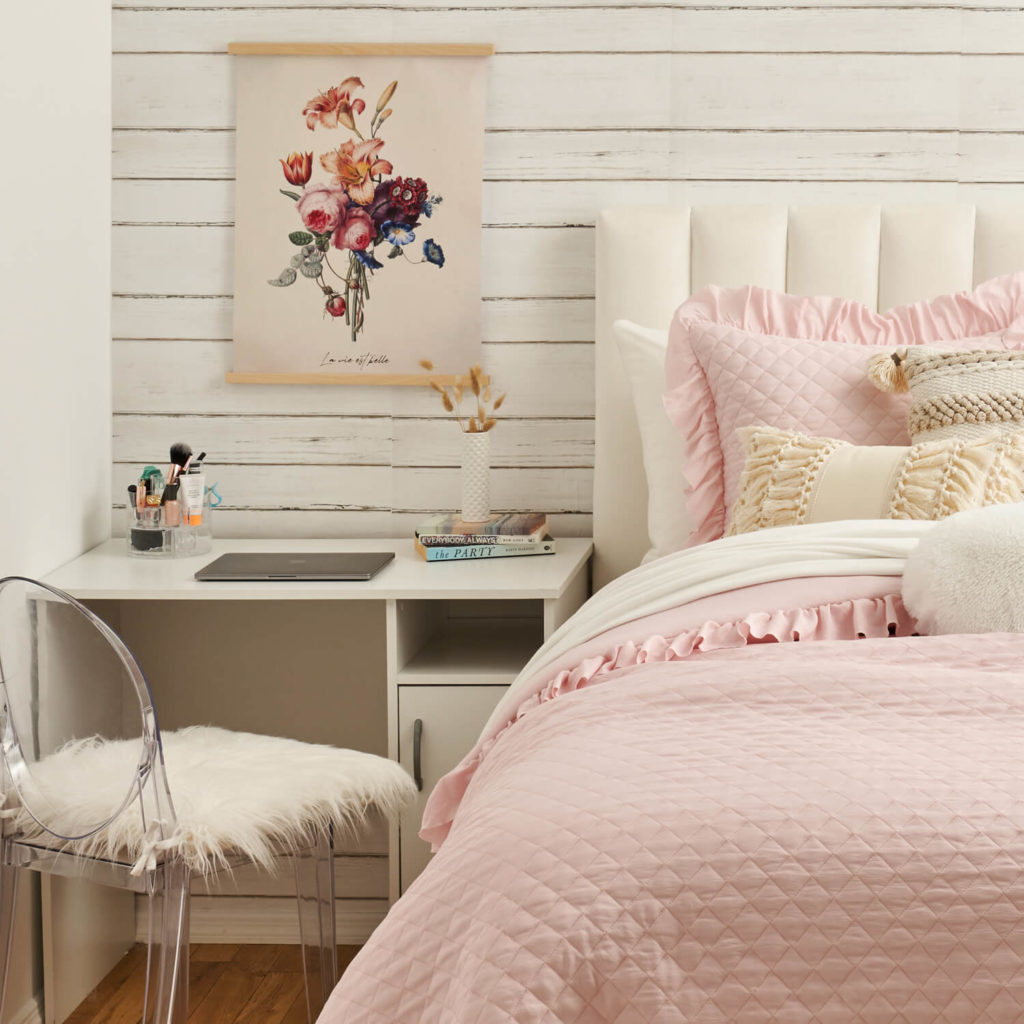 Cute pink bedroom idea from Dormify with flower print on the wall and pink frilly bedding