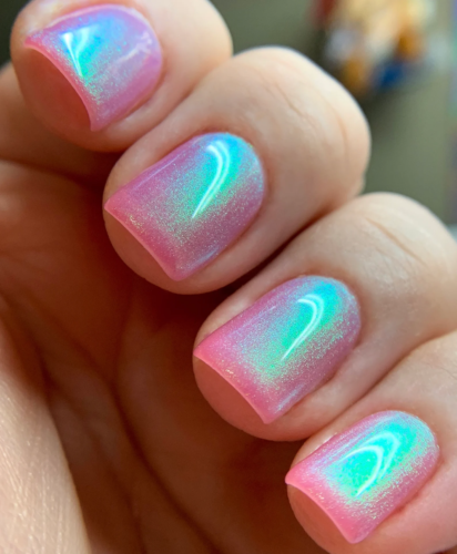 Pastel iridescent short nails, shown in a pale pink polish with light green and purple iridescent shimmer