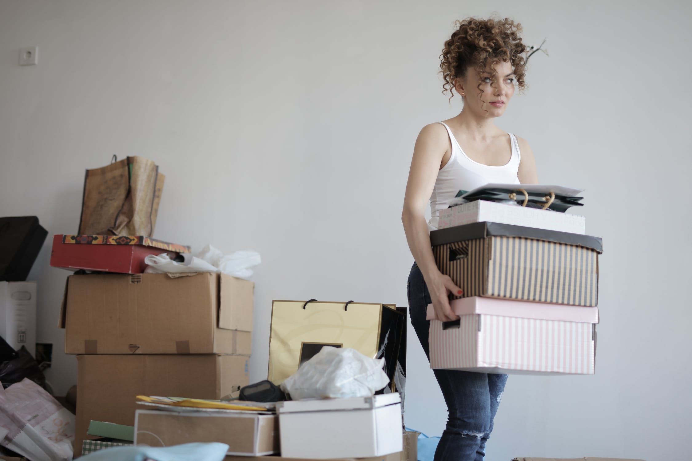 Woman holding a bunch of moving boxes