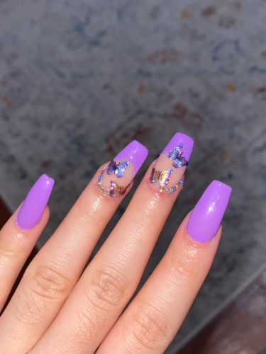 Bright purple acrylic nails with butterflies and rhinestones