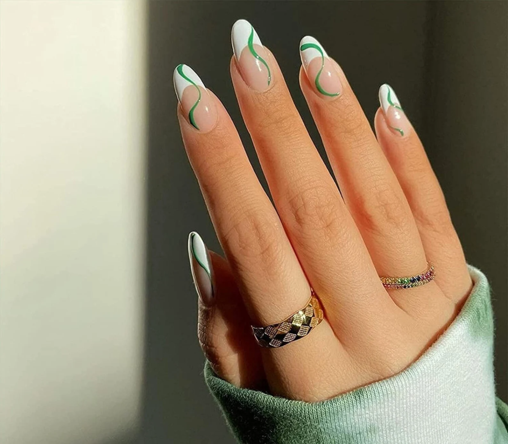 White french tip nails with green swirls