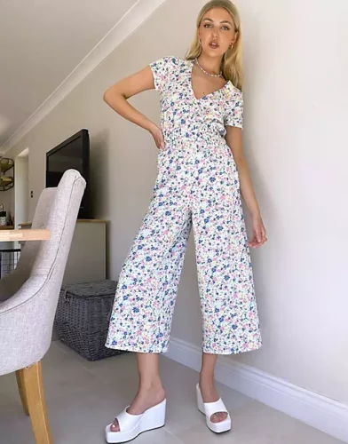 A floral pastel jumpsuit and white mules.