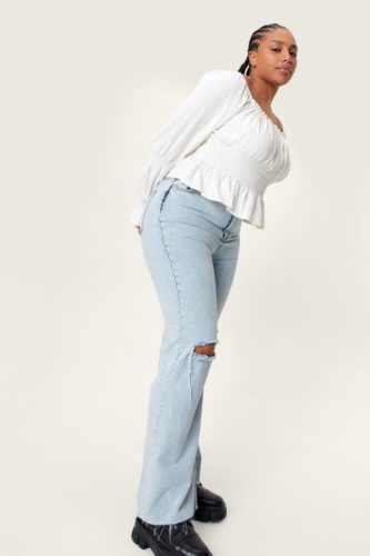 Midsize Fashion - A linen white smocked long sleeve top, light wash distressed denim jeans and black boots.