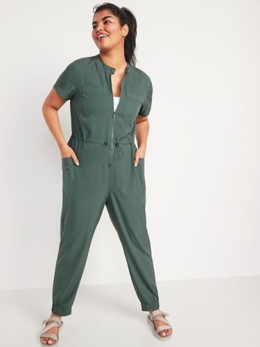 A green collarless jumpsuit and tan sandals.