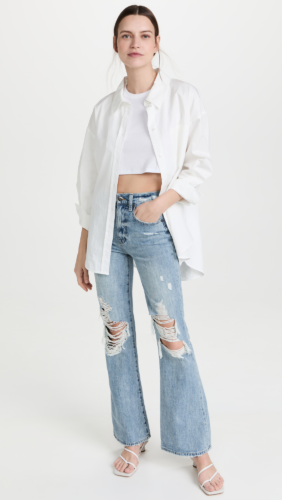 Flare jeans outfit with ripped flares, crop top, oversized button-down shirt and heels