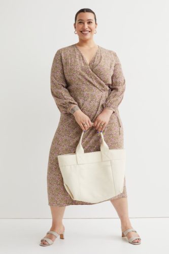 A patterned wrap dress, cream tote bag and beige heels.