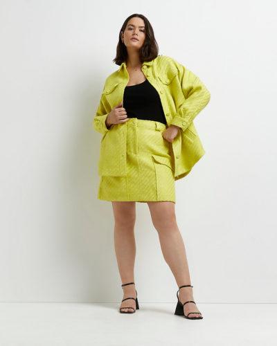 A yellow jacket and matching skirt, black top and black strap heels.