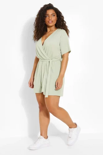 A sage green wrap romper and white sneakers.
