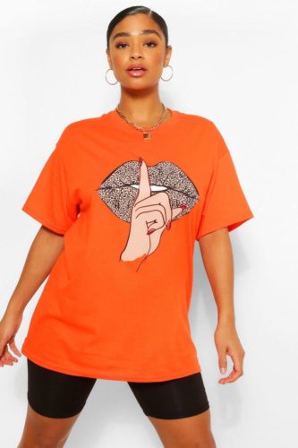 An orange leopard lip graphic t-shirt and black bike shorts.