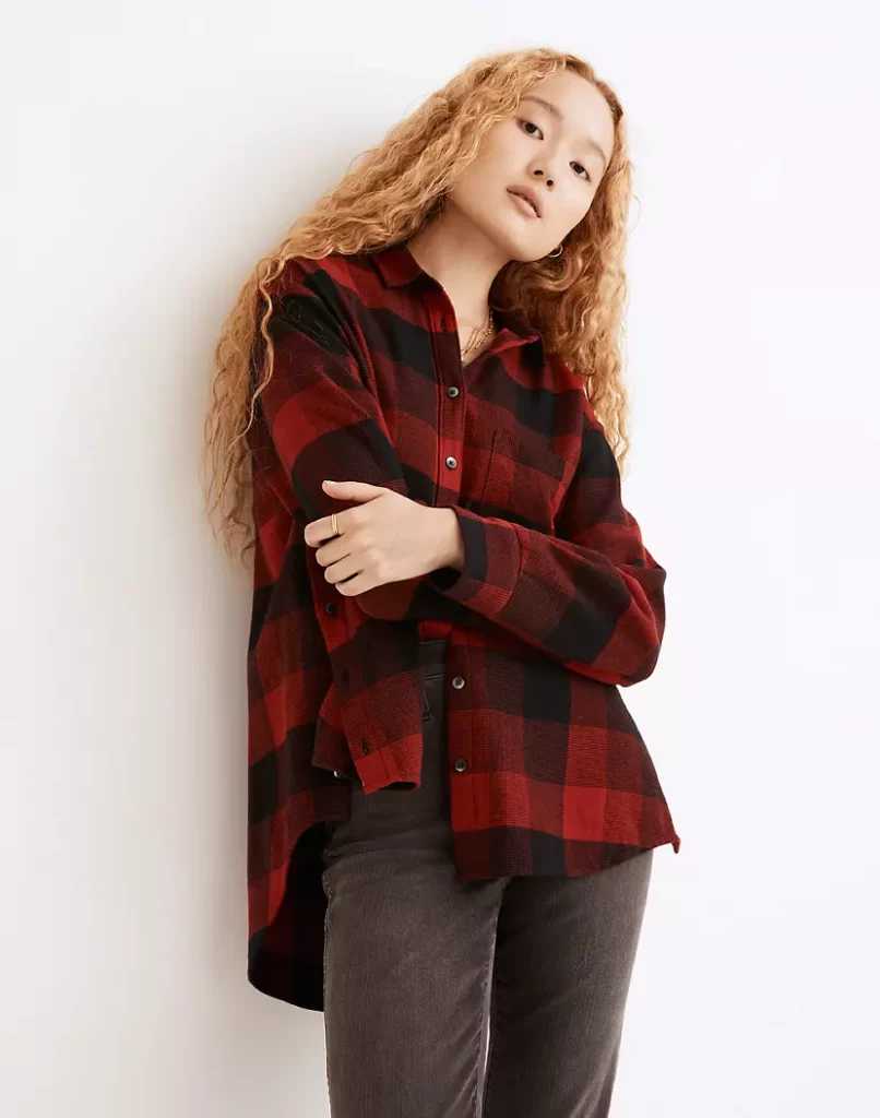 A red flannel top and dark wash denim jeans.