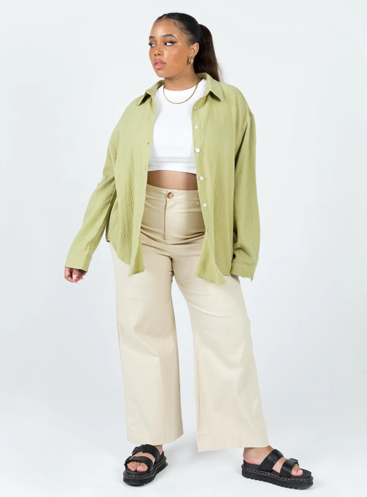 Casual outfit for a baseball game -- wide leg pants, cropped tee, oversized shacket, dad sandals