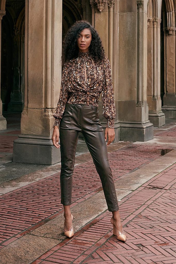 An outfit with brown faux leather pants and nude pointed toe pumps.