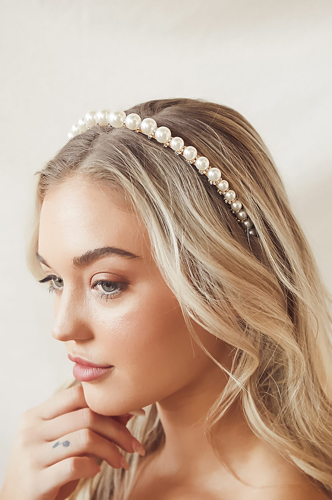 Blonde woman wearing a pearl-embellished headband on wavy hair