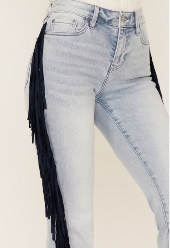 pair of light wash regular rise jeans with navy suede fringe down the sides on a model