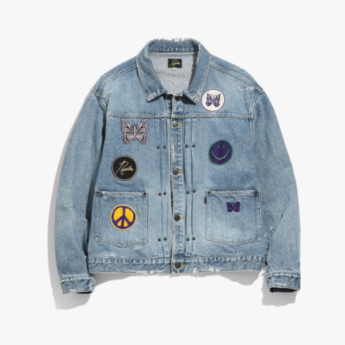Light wash oversized jean jacket with small dark silver buttons and butterfly, peace, smiley face, and logo patches