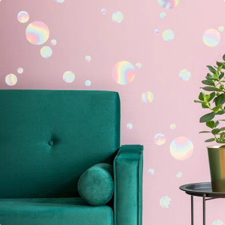 iridescent bubble wall decals on pink wall with green couch and plant