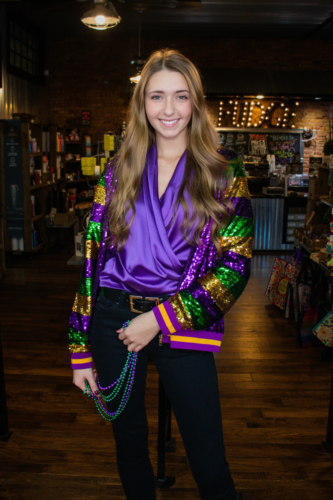 Mardi Gras outfit with purple satin top, sequined jacket, skinny jeans and belt
