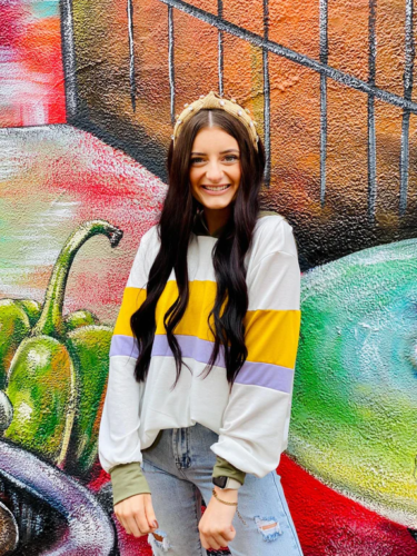 Mardi Gras outfit with a striped hoodie in mardi gras colors and ripped jeans