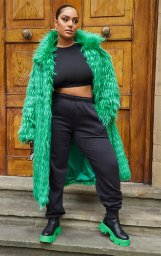 Cool plus size mardi gras outfit with black crop top and joggers, oversized green faux fur coat, green and black sneakers