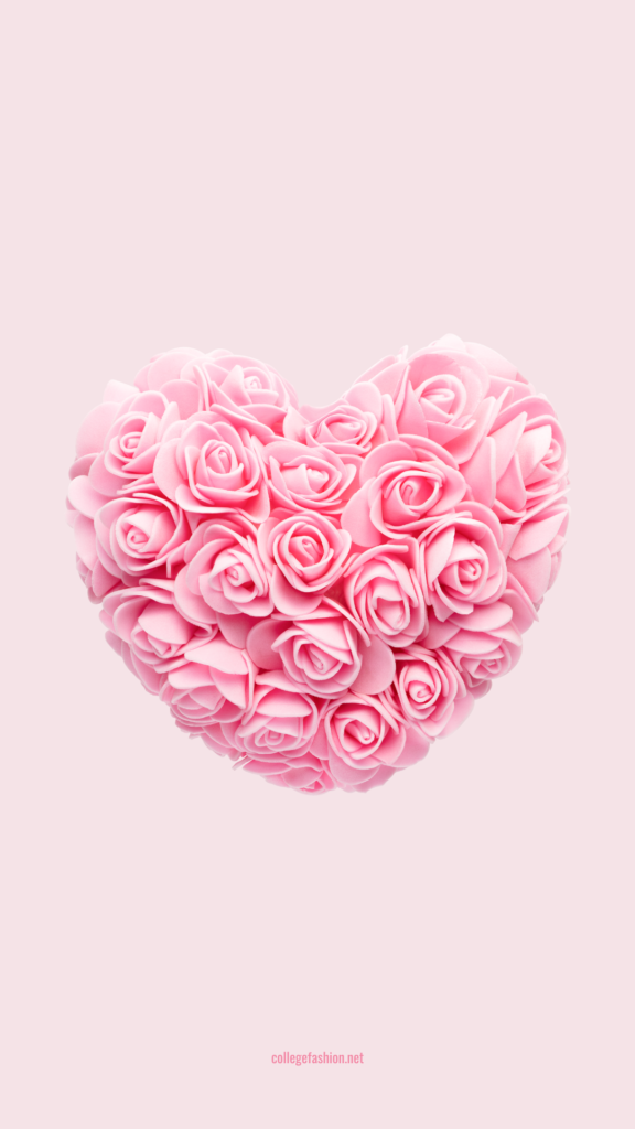 Pink heart made out of roses on a pink background
