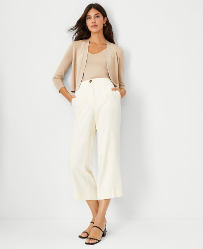 Business casual outfit for summer: Cream cropped wide leg pants, beige shell and cardigan set, black open toe heels